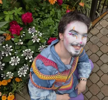 a downward angle on a clown kneeling in the flowers